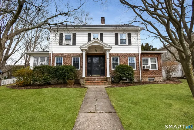 a front view of a house with a garden and yard