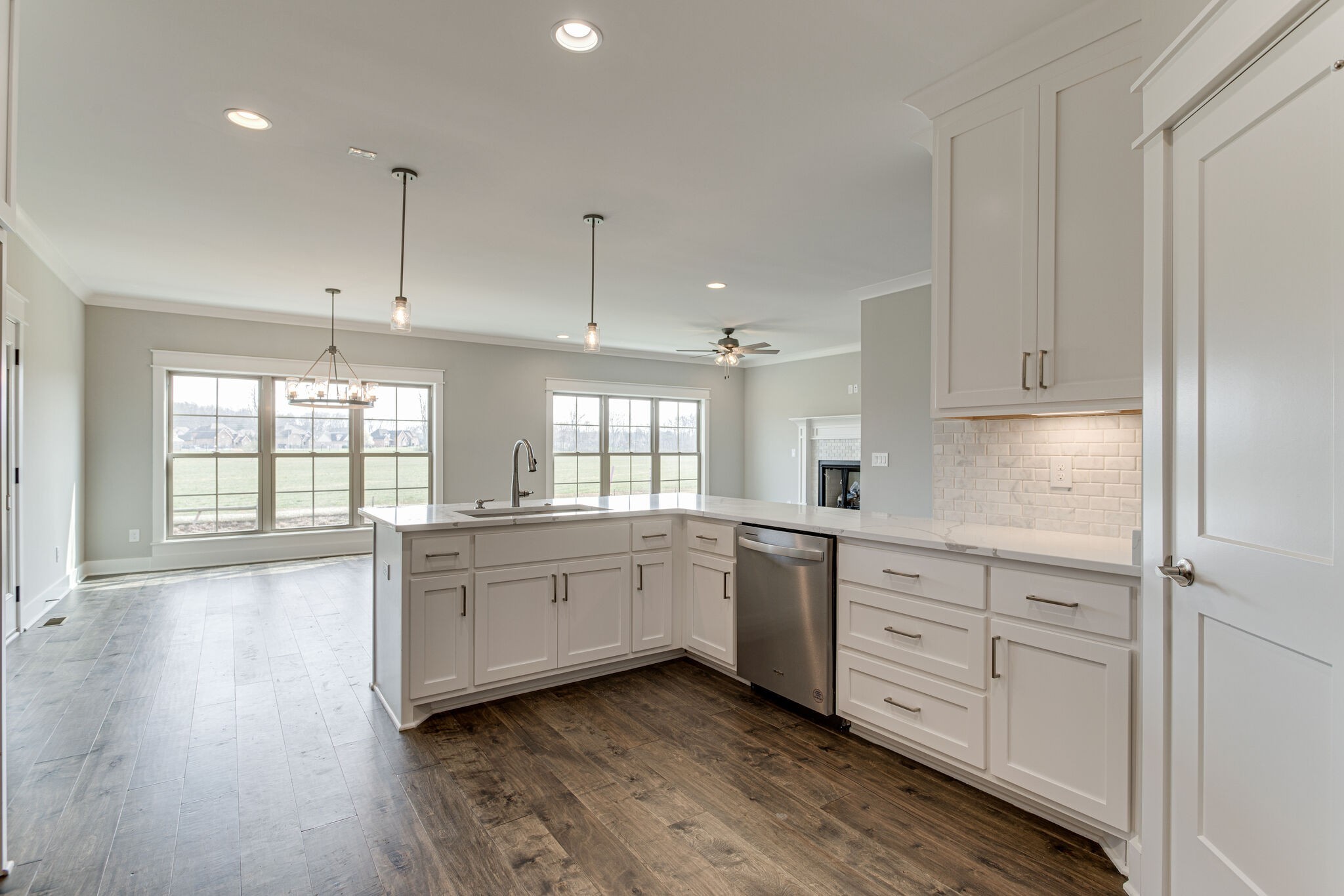 2617 Holly Spring Drive Murfreesboro, TN 37128 - Photo 28 of 50 a large white kitchen with granite countertop a stove a sink and white cabinets with wooden floor next to windows