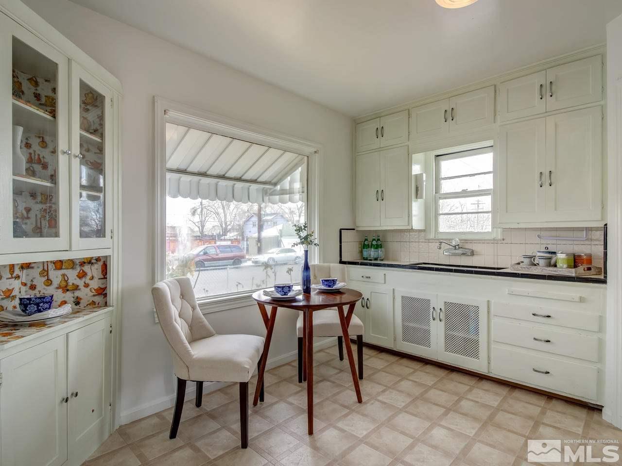 1215 Wheeler Avenue Reno, NV 89502 - Photo 9 of 25 a kitchen with granite countertop a table chairs and white cabinets