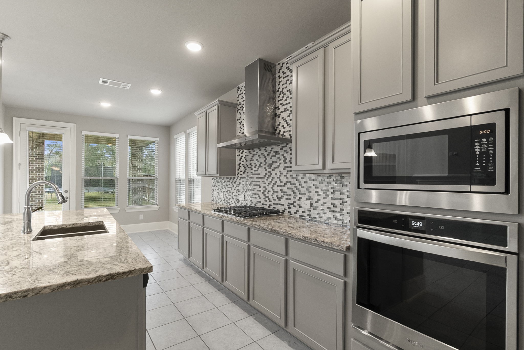 8710 Burdekin Road Magnolia, TX 77354 - Photo 16 of 49 a kitchen with stainless steel appliances granite countertop a stove microwave and sink