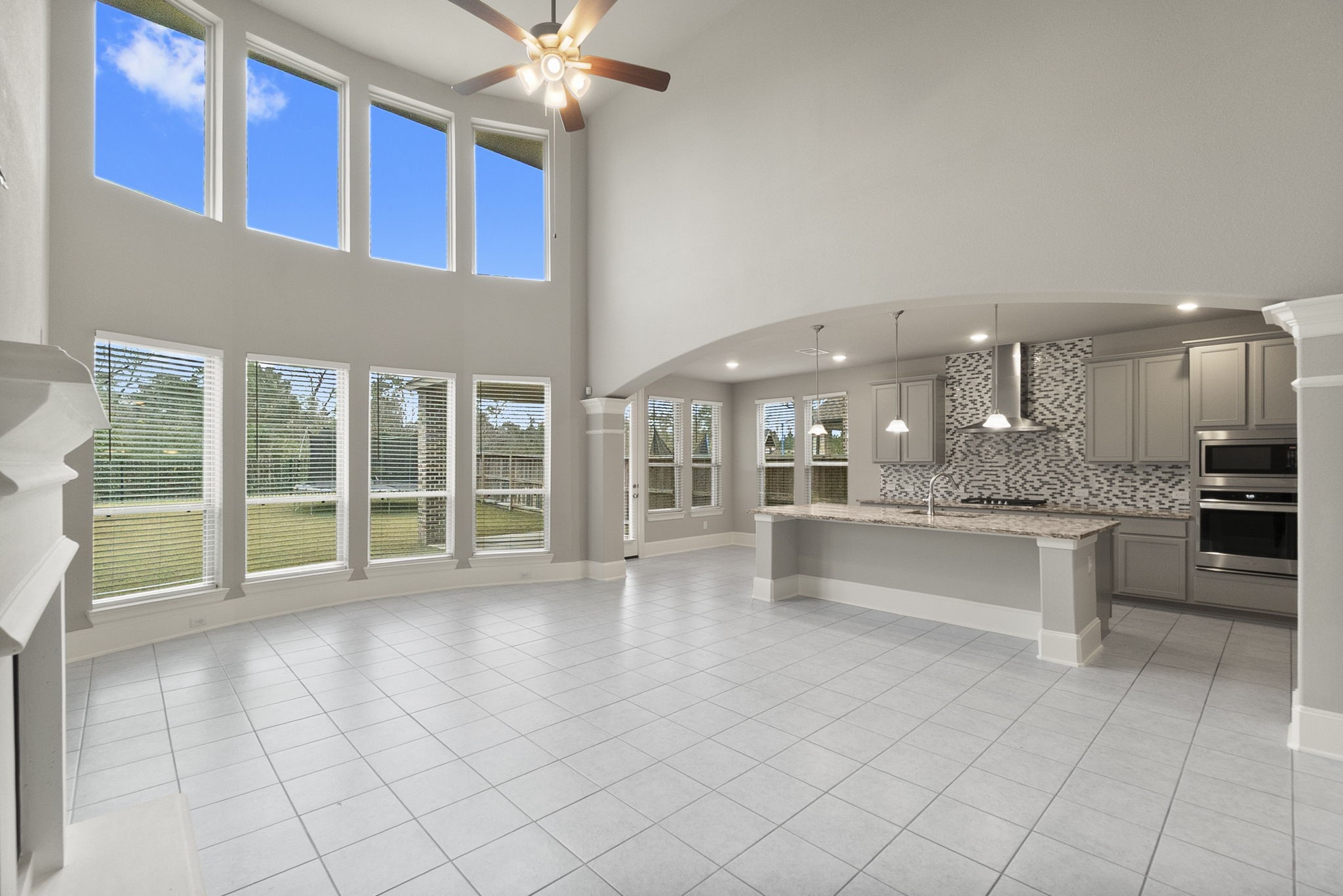 8710 Burdekin Road Magnolia, TX 77354 - Photo 9 of 49 a large white kitchen with kitchen island granite countertop a large window and a sink