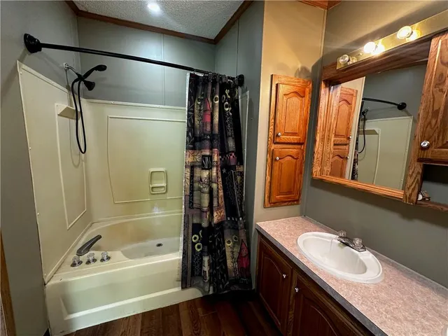 a bathroom with a tub sink a mirror a shower and vanity