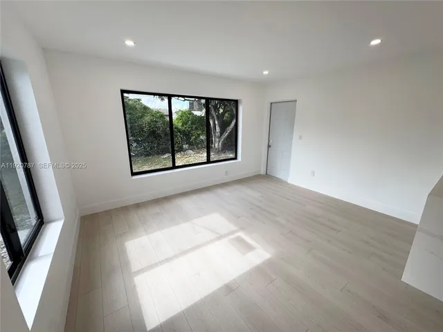 an empty room with windows and cabinet