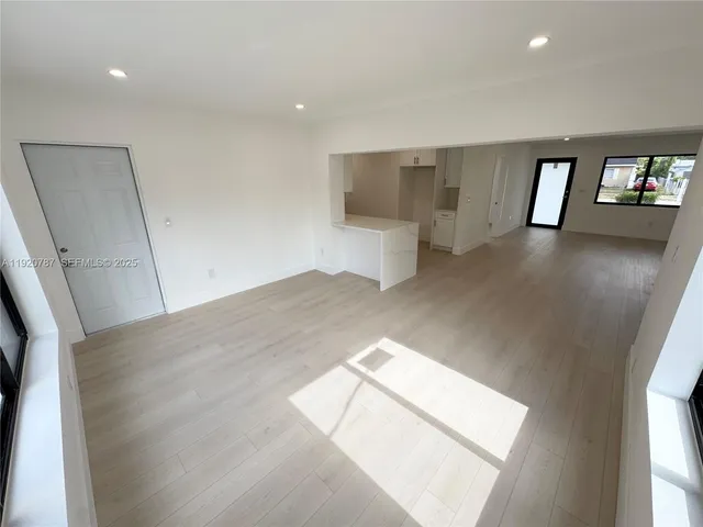 a large white kitchen with white cabinets and a refrigerator