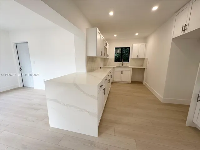 a kitchen with a sink a stove and cabinets