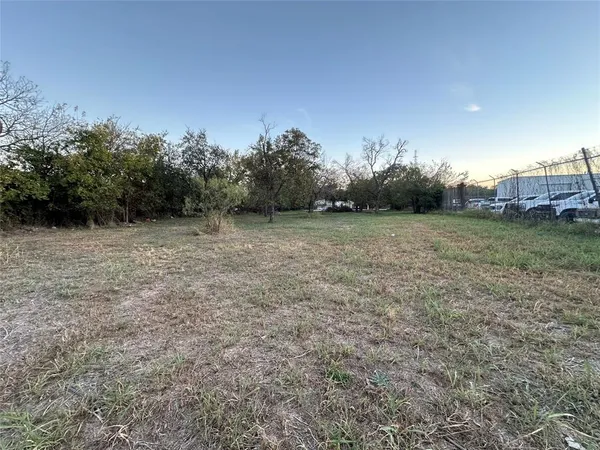 a view of a field with trees in background