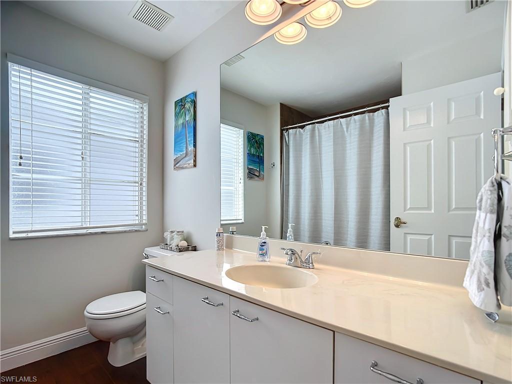 2860 Citrus Lake Drive, Unit R202 Naples, FL 34109 - Photo 28 of 50 a bathroom with a sink and a large mirror
