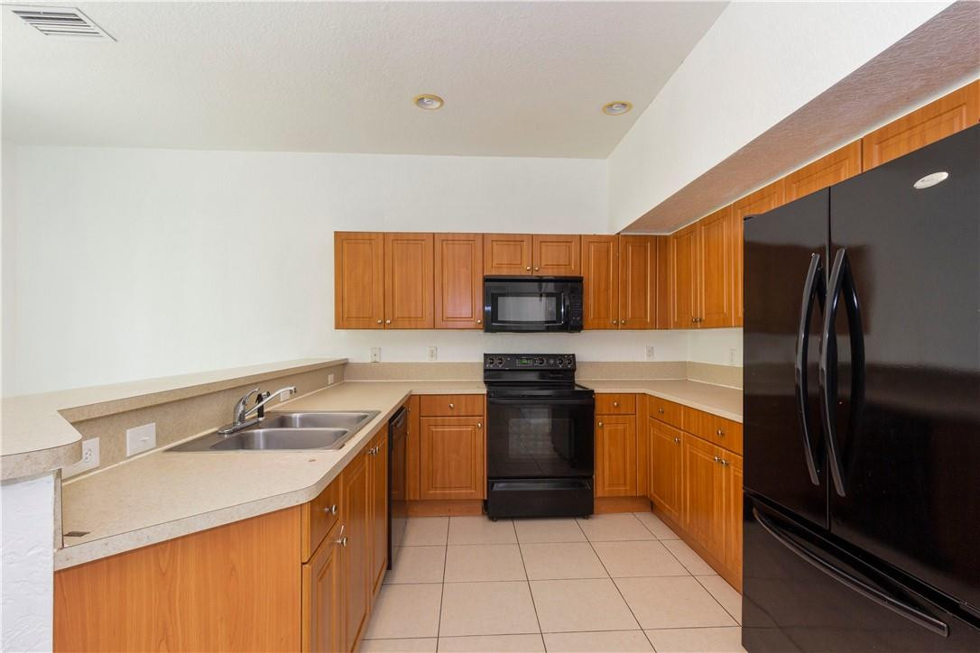 1801 Northwest 3rd Street Pompano Beach, FL 33069 - Photo 8 of 25 a kitchen with stainless steel appliances granite countertop a sink stove and refrigerator