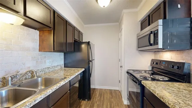 a kitchen with stainless steel appliances granite countertop a sink stove and refrigerator