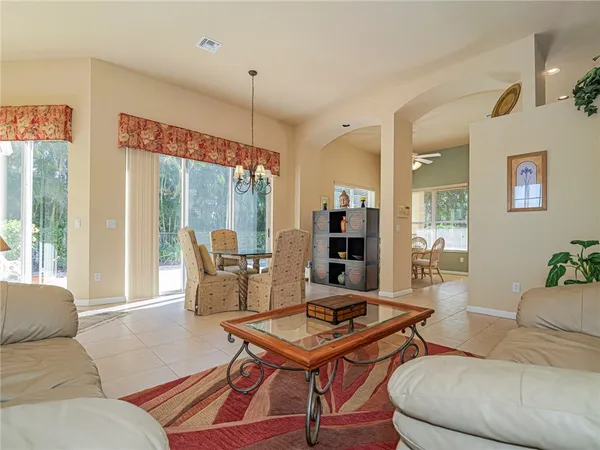 a living room with furniture a table and a large window