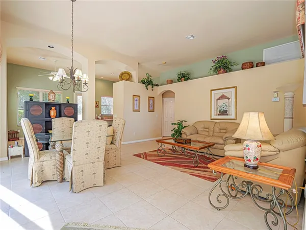 a living room with furniture a chandelier and a table