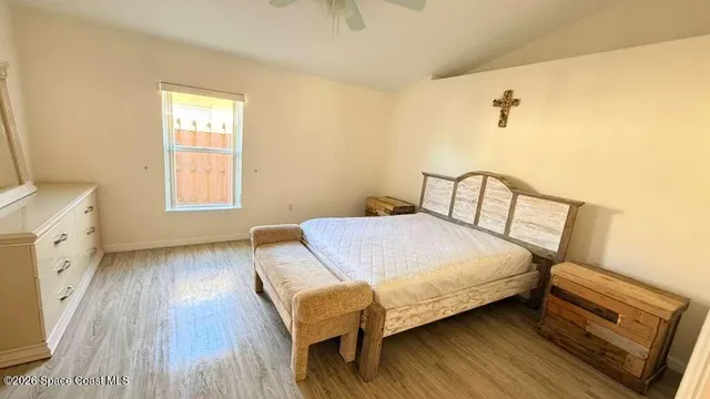 a bedroom with a bed and wooden floor