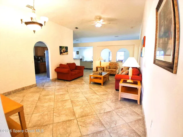 a living room with furniture and a chandelier