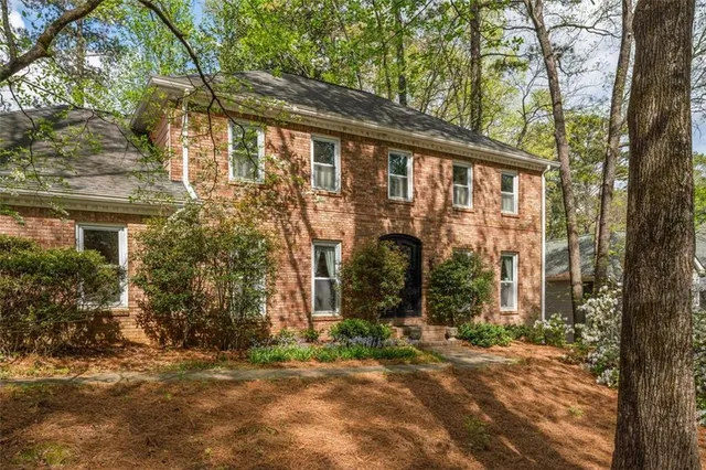 a view of a house with backyard and trees