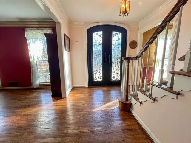 a view of a hallway with wooden floor and windows