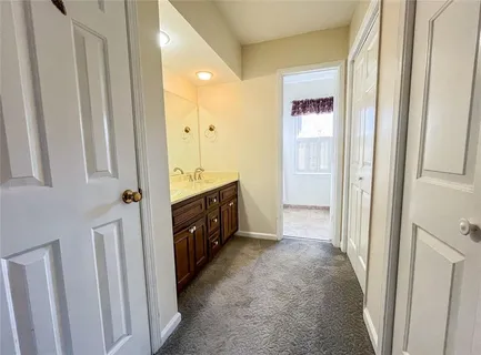a spacious bathroom with a double vanity sink a mirror and a shower