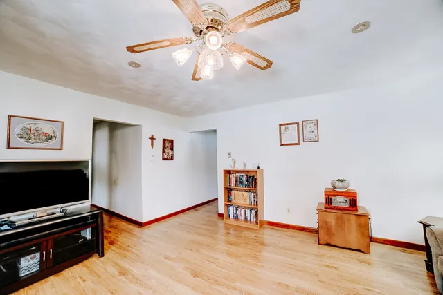 a bedroom with a bed and a dresser with wooden floor