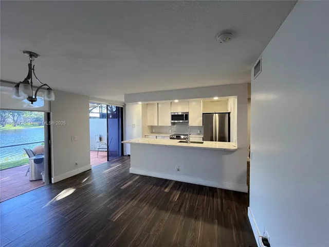 a kitchen with stainless steel appliances a sink stove refrigerator and cabinets