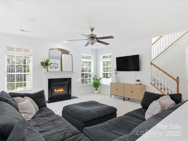 a living room with furniture a flat screen tv and a fireplace