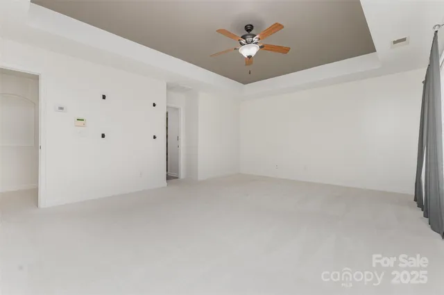 an empty room with a ceiling fan and a window