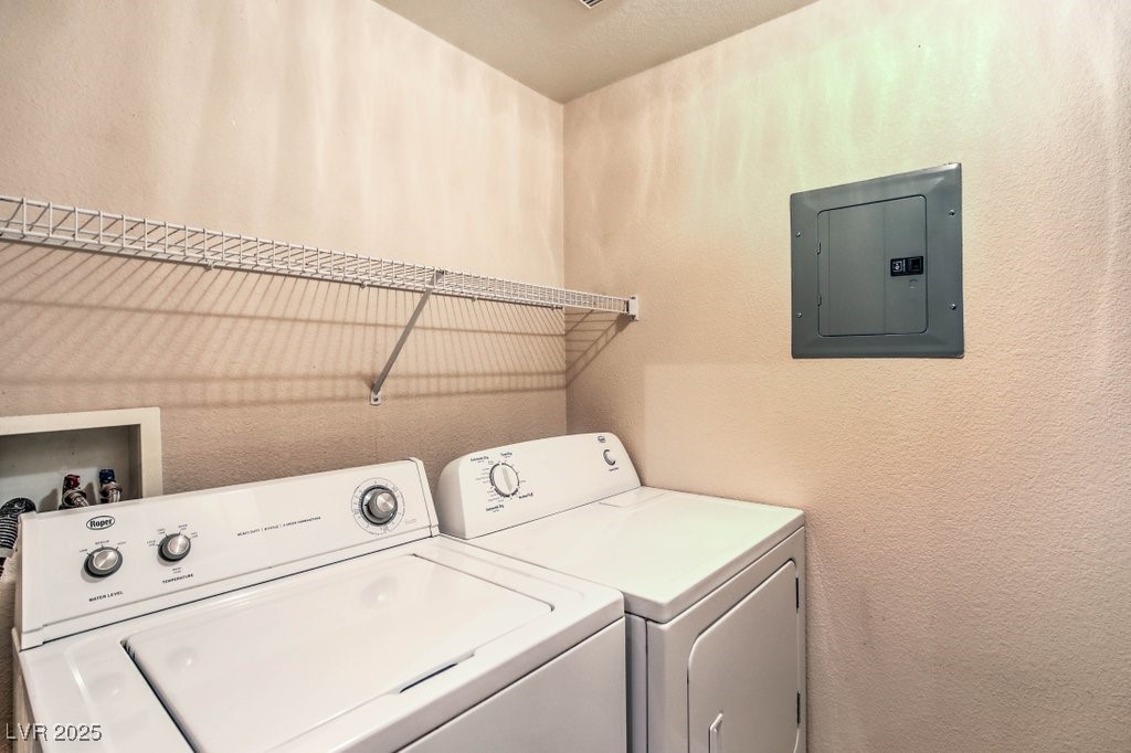 7119 South Durango Drive, Unit 207 Las Vegas, NV 89113 - Photo 11 of 35 Laundry area featuring a textured wall, electric panel, washer and dryer, and a textured ceiling
