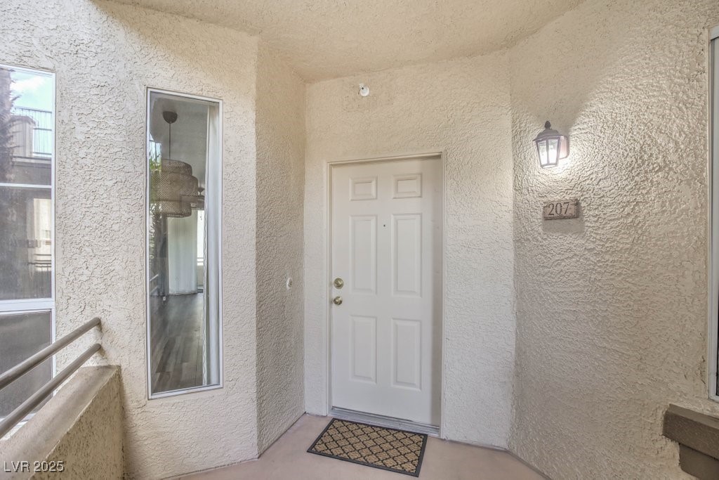 7119 South Durango Drive, Unit 207 Las Vegas, NV 89113 - Photo 9 of 35 Doorway to property with stucco siding