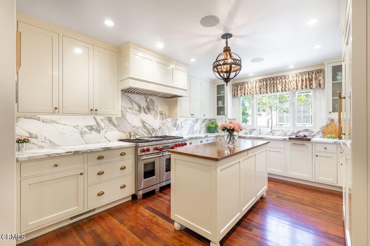 735 Holladay Road Pasadena, CA 91106 - Photo 13 of 72 a kitchen with granite countertop a stove a sink and white cabinets with wooden floor