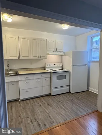 a kitchen with granite countertop white cabinets and white appliances