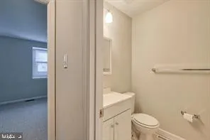 a bathroom with a granite countertop toilet a sink and a mirror