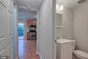 a view of a hallway and wooden floor and a sink