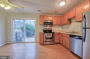 a kitchen with granite countertop a refrigerator stove top oven and sink
