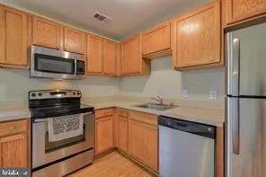 a kitchen with stainless steel appliances granite countertop a stove microwave and refrigerator