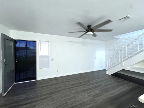 a view of an empty room with wooden floor