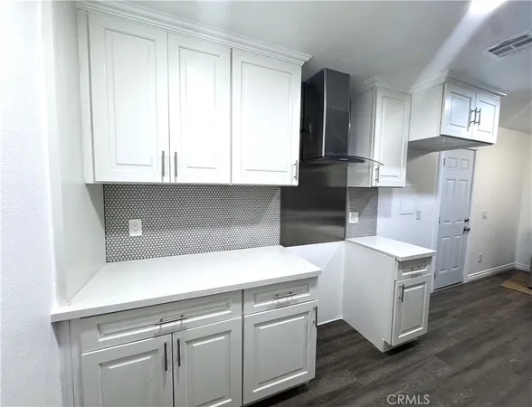 a kitchen with cabinets appliances and a wooden floor