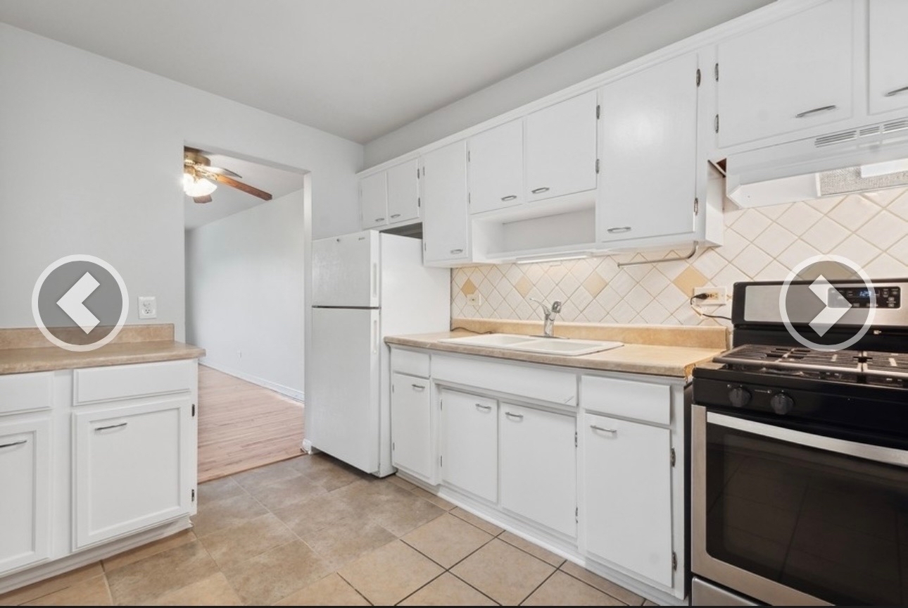 7019 North Ridge Boulevard, Unit 3B Chicago, IL 60645 - Photo 3 of 6 a kitchen with white cabinets and a stove