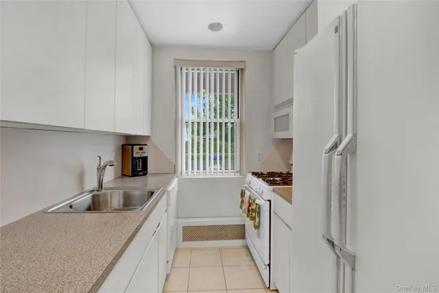 a kitchen that has a sink a stove and a refrigerator