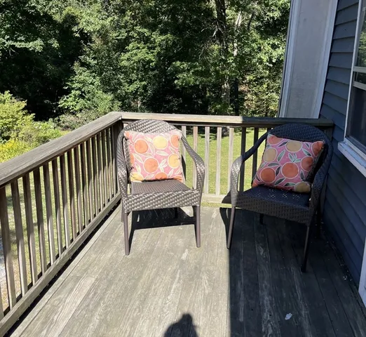a view of balcony with wooden floor and seating space