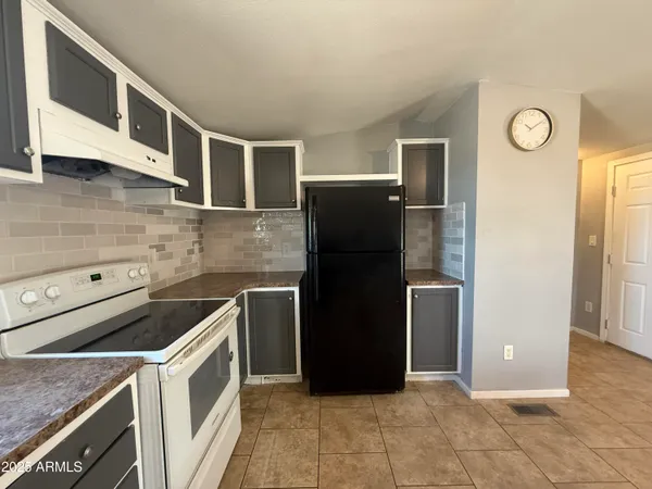 a kitchen with a refrigerator and a stove