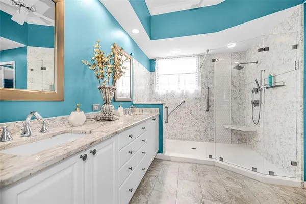 a bathroom with a granite countertop sink mirror and shower