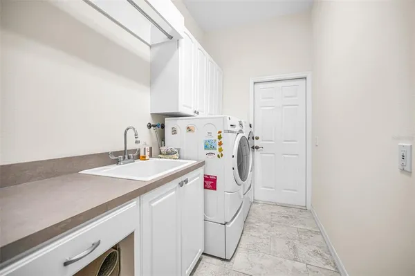 a utility room with sink dryer and washer