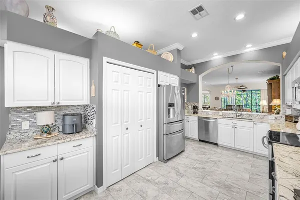 a kitchen with granite countertop cabinets stainless steel appliances a sink and a large window