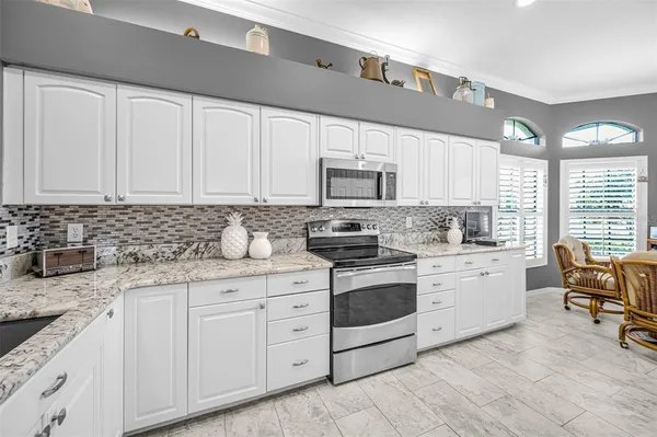 a kitchen with granite countertop white cabinets white stainless steel appliances with a sink and dishwasher