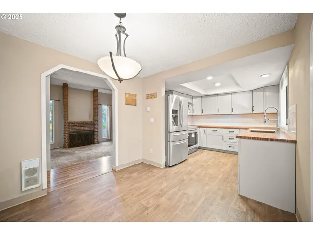 a open kitchen with stainless steel appliances granite countertop a refrigerator and a sink