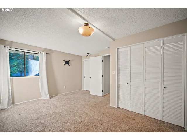 a bathroom with a granite countertop sink a toilet a mirror and shower