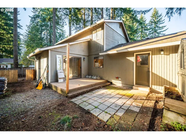 a view of a backyard with large tree and wooden fence