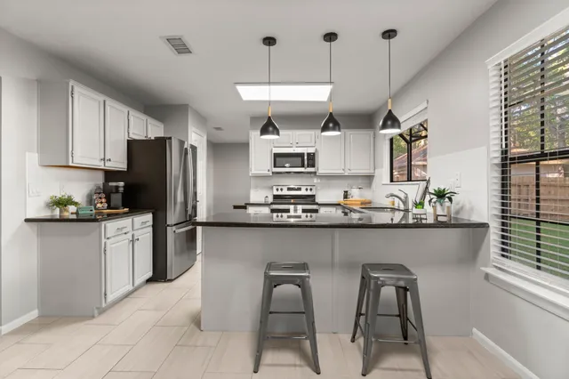 a kitchen with granite countertop a sink and appliances