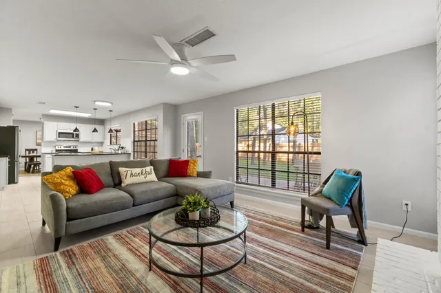 a living room with furniture fireplace and a large window