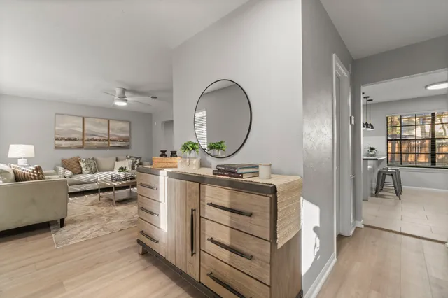 a living room with furniture a mirror and a table