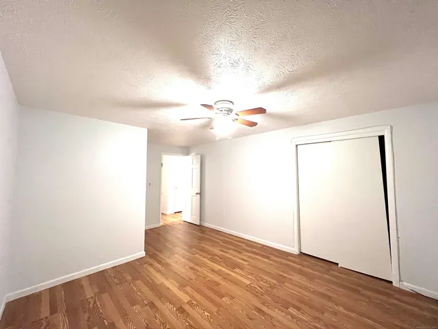 a view of a big room with wooden floor and a window