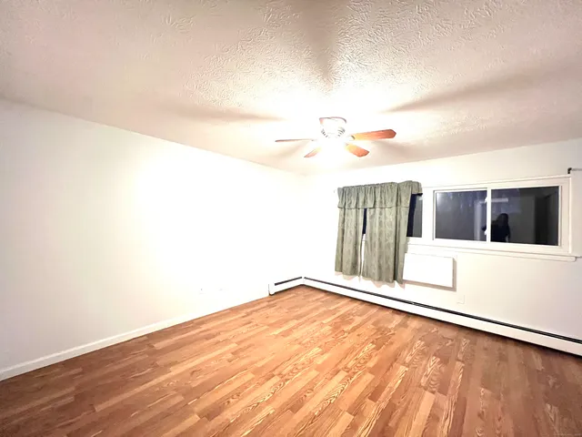a view of a room with wooden floor and fan